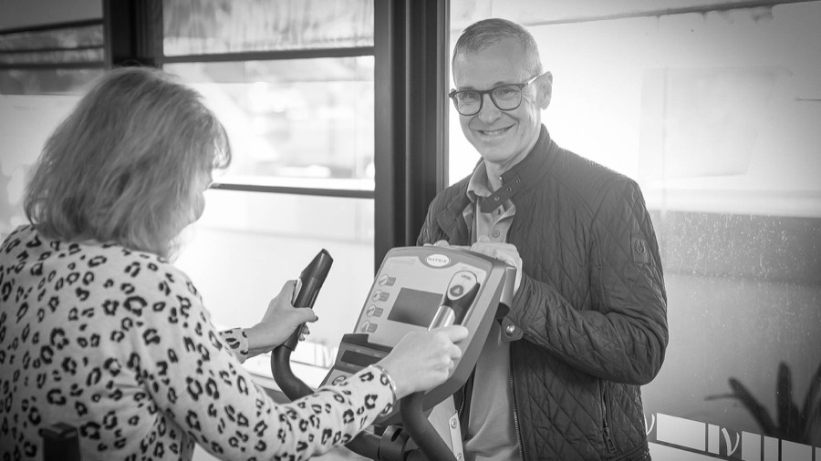 Miles Browning supporting an older adult during exercise assessment